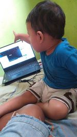 Rear view of boy using mobile phone