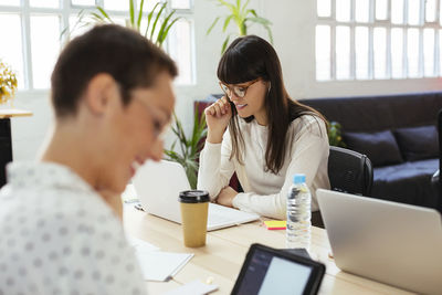 Smiling colleagues working at desk in office