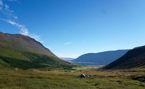 Scenic view of mountains against blue sky