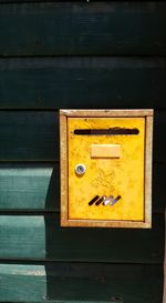 Close-up of mailbox on yellow wall