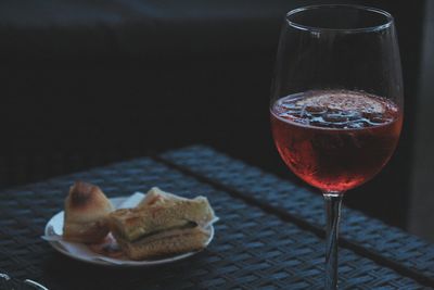 Close-up of wine in glass by bread on table