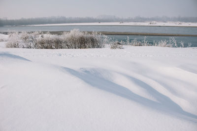 Scenic view of lake against sky during winter