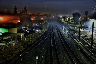 Railway tracks against sky at night