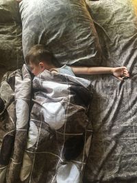 High angle view of cute boy relaxing on bed