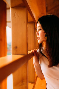 Portrait of woman looking away while standing on ceiling