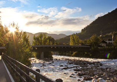 Bridge over river against sky during sunset