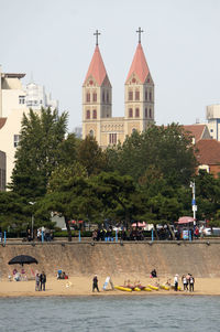 People in park by city against sky