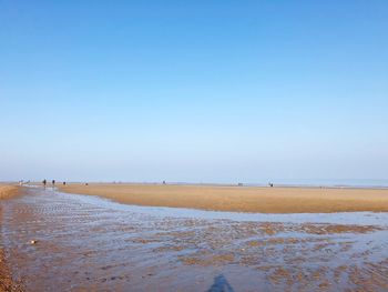 Scenic view of beach against clear blue sky