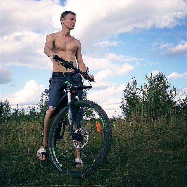 young adult, sky, lifestyles, leisure activity, full length, cloud - sky, person, casual clothing, young men, standing, cloud, transportation, front view, bicycle, side view, field, grass