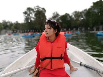 Woman looking at boat in lake against sky