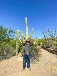 Full length of man standing on field against clear sky