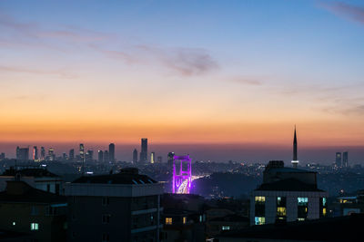 Illuminated city against sky during sunset