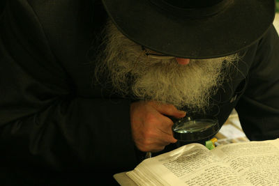 Detective reading book through magnifying glass