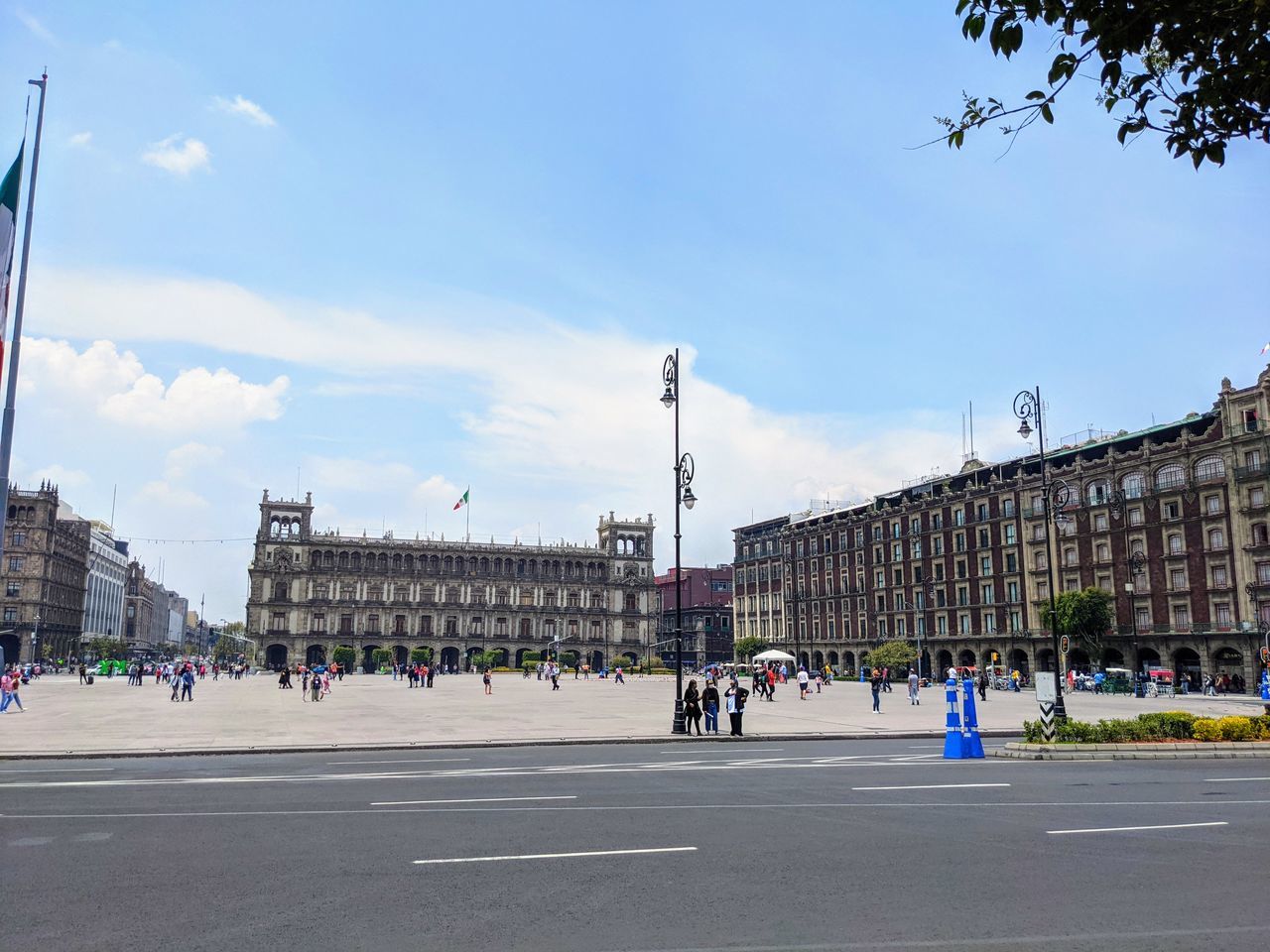 PEOPLE ON ROAD BY BUILDINGS AGAINST SKY