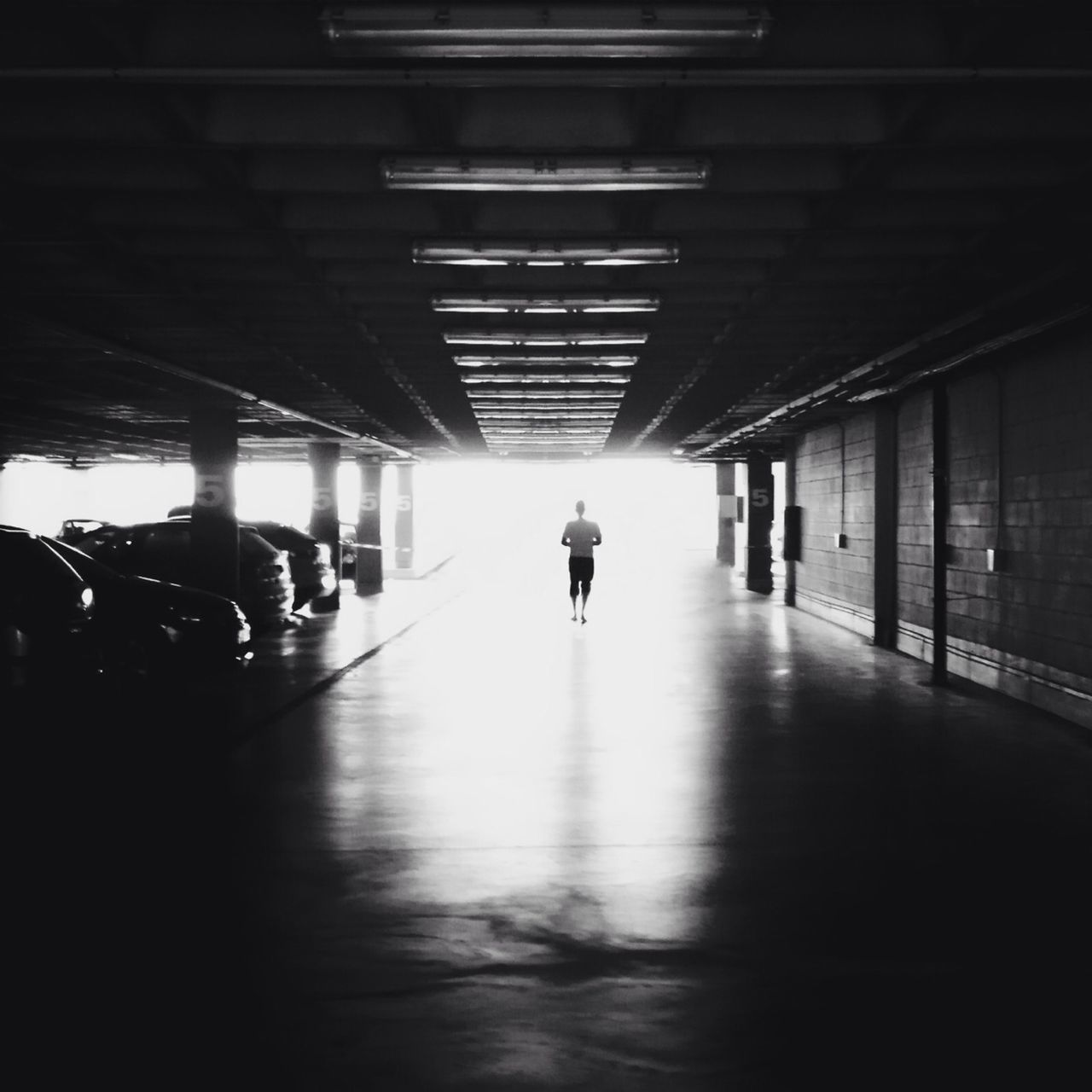 indoors, full length, walking, lifestyles, men, transportation, architecture, built structure, rear view, illuminated, silhouette, leisure activity, ceiling, city life, the way forward, tunnel, on the move, flooring