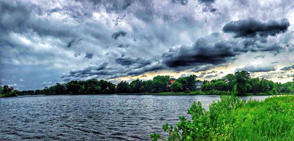 Scenic view of lake against cloudy sky