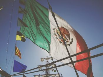 Low angle view of flags hanging against sky