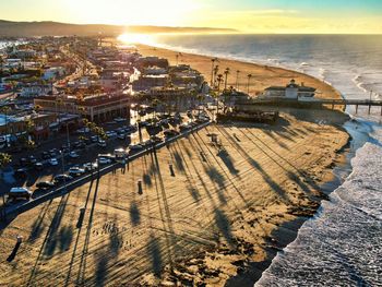 High angle view of townscape by sea against sky during sunset