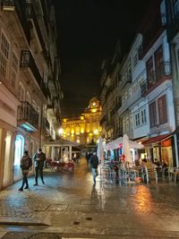 People in illuminated city at night