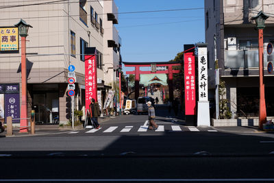 People on street against buildings in city