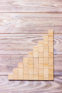 A wooden blocks cube over black wooden textured background with copy space 