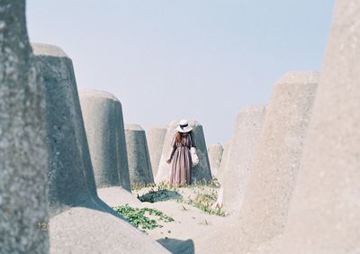 Man leaning on rock against wall