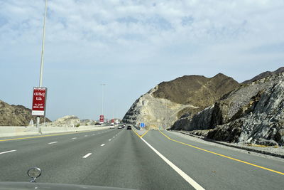 Road leading towards mountain against sky