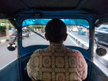 Rear view of man standing in car