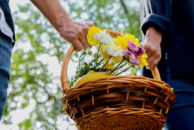 Close-up of man holding flowers in basket
