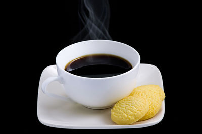 Close-up of coffee cup against black background