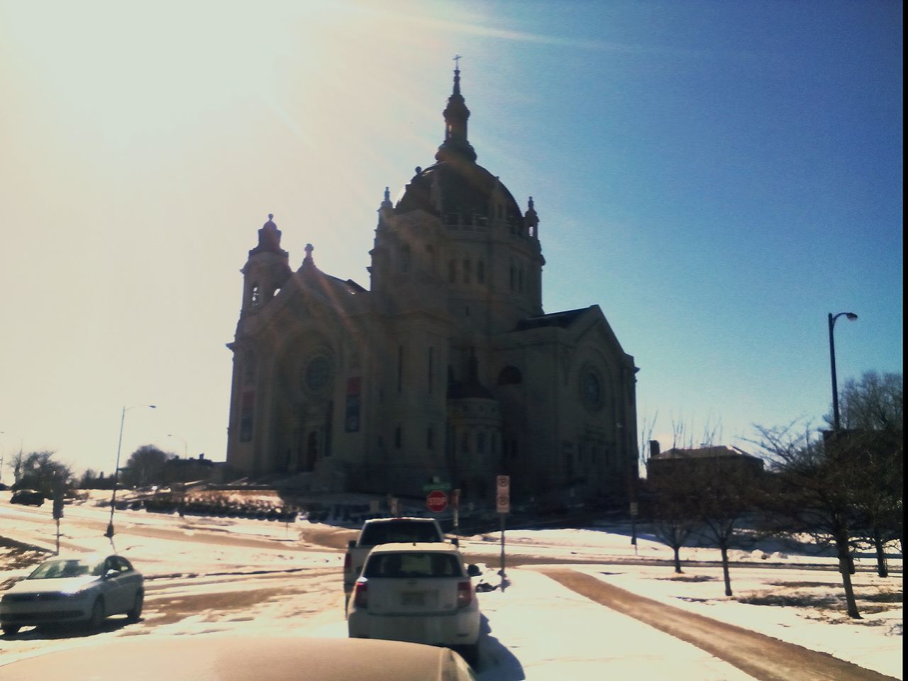 building exterior, architecture, built structure, transportation, car, land vehicle, clear sky, mode of transport, church, place of worship, religion, street, road, spirituality, travel, winter, incidental people, sunlight