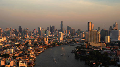 Aerial view of buildings in city during sunset