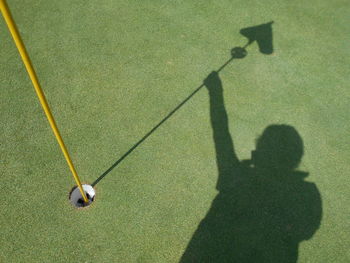 High angle view of shadow of man on golf course