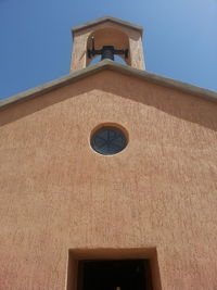 Low angle view of bell tower against blue sky