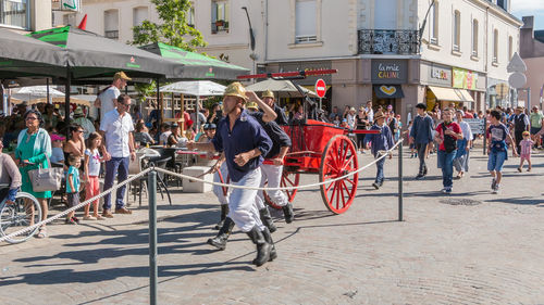 People on street against buildings in city