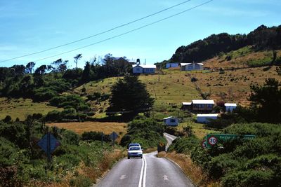 Cars on road by mountain against sky