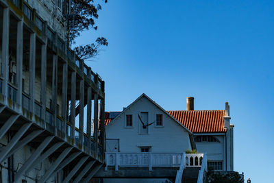 Low angle view of buildings against clear blue sky