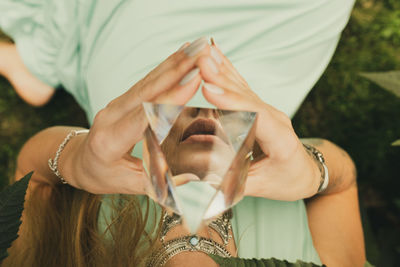 Midsection of woman holding crystal pyramid