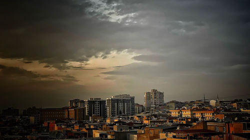 Buildings in city against sky during sunset