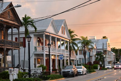Houses by street in city against sky