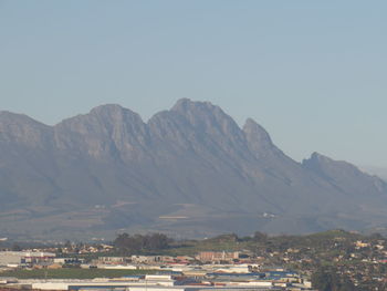 Townscape by mountains against clear sky