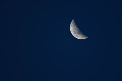 Low angle view of half moon against clear sky at night