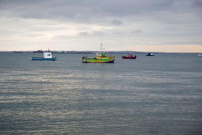 Boats sailing in sea against sky