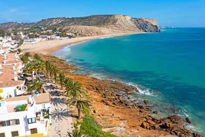 Aerial view of houses by beach against sky