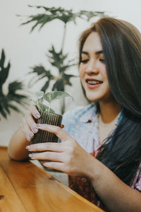 Young woman holding drink on table