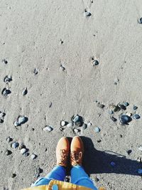 Low section of woman standing on sand