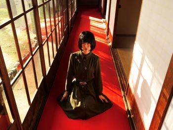 High angle view of woman sitting in corridor