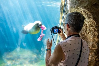 Full length of man photographing at sea