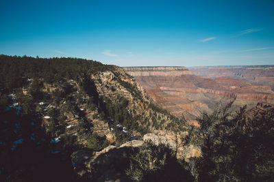 Scenic view of dramatic landscape against blue sky