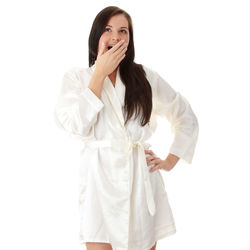 Young woman looking away while standing against white background